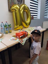 Bartek pozuje do zdjęcia przy urodzinowym torcie w kształcie wozu strażackiego